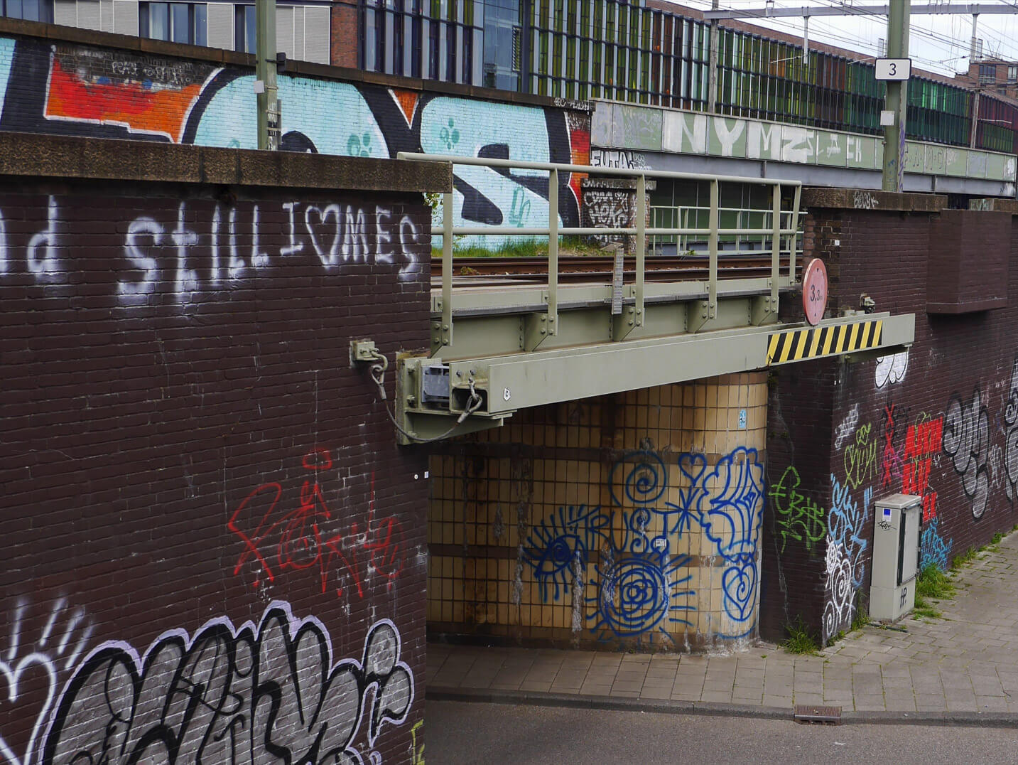 A railway bridge covered in graffiti.